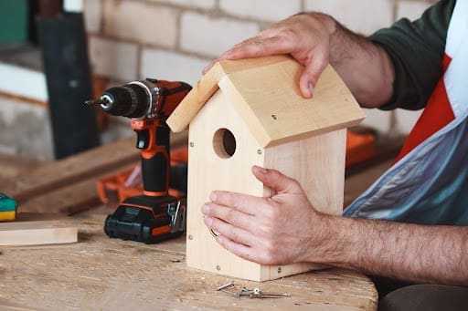 older man buidling a birdhouse, an easy woodworking project for seniors