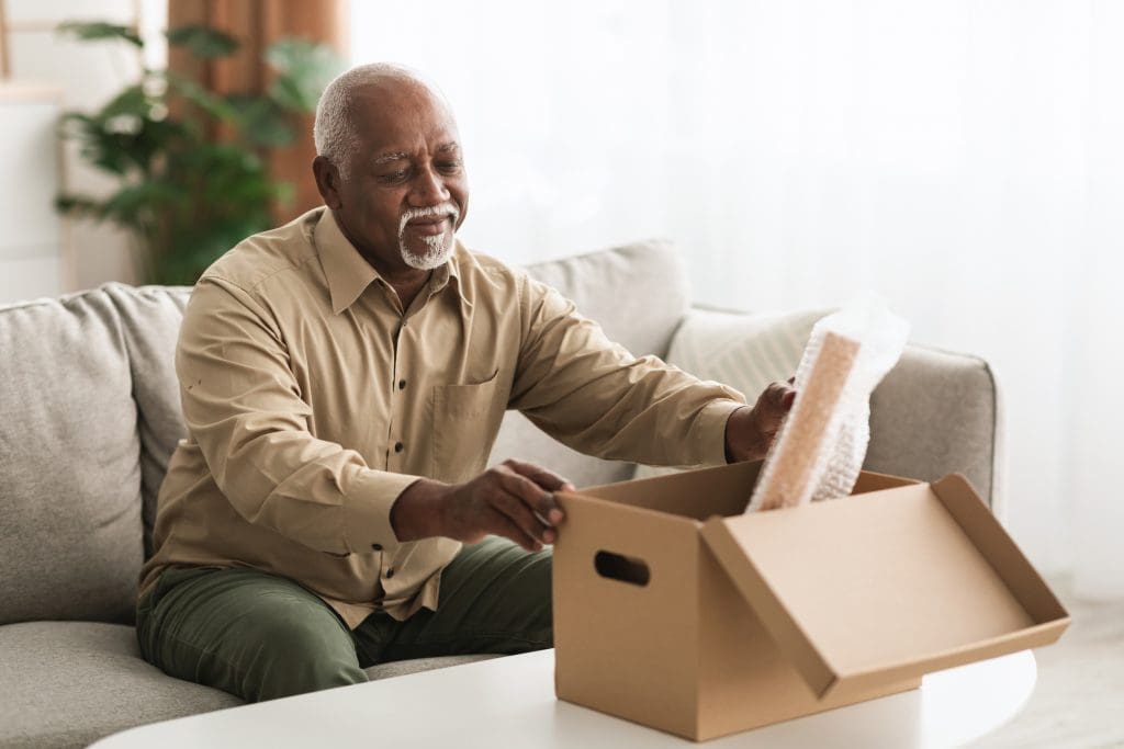 Senior Man Packing Stuff Putting His Belongings In Cardboard Box