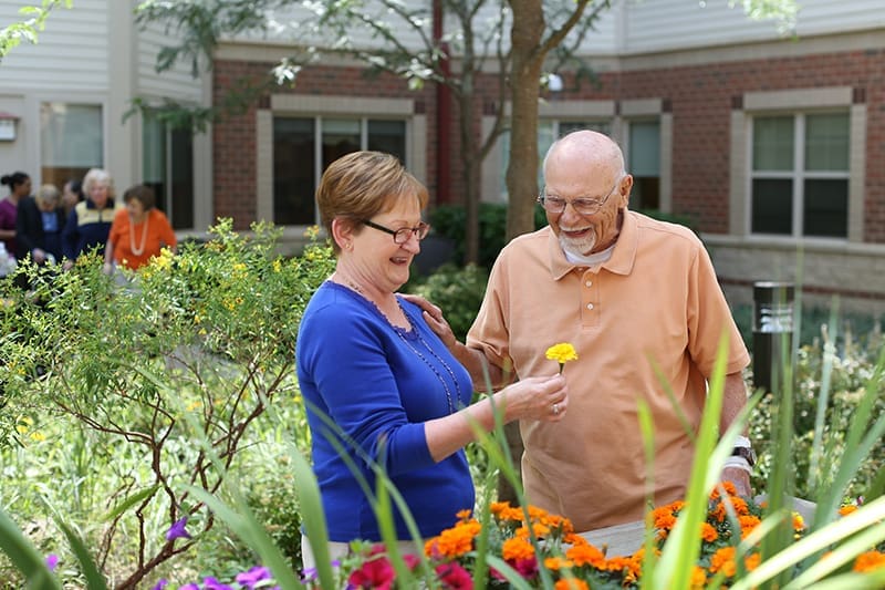 Man and woman enjoying flowers in a garden