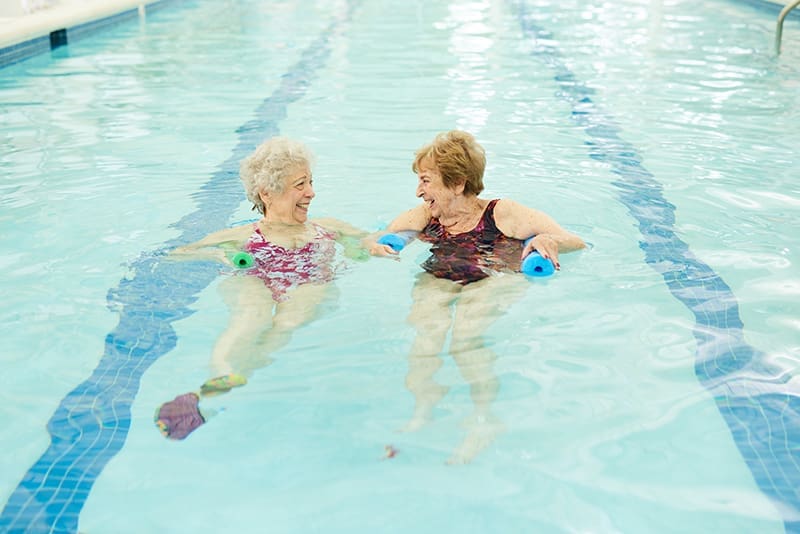 Two women swimming in pool